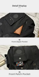 Detailed front storage compartments of black nylon backpack showing zipper pocket and phone pouch