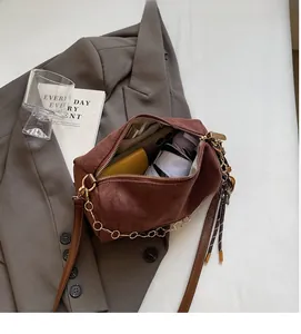 Vista interna dell'ampia capacità della borsa boston in camoscio marrone con tracolla