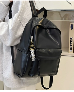 Detail of minimalist black PU leather backpack with silver bear charm and Boog logo