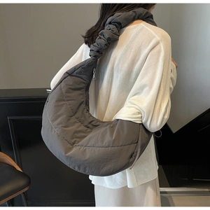 Detail of grey quilted nylon crescent bag featuring stylish ruched shoulder strap detail