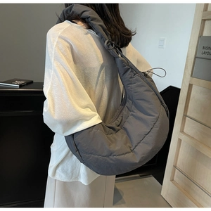 Rear view of a dark grey quilted crescent shoulder bag made of soft nylon fabric