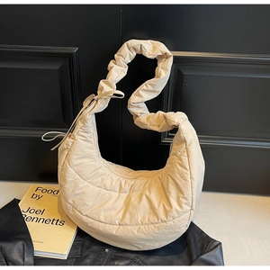 Detail of light beige quilted cloud bag showing ruching texture and drawstring strap