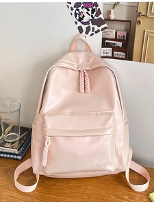 Pink minimalist PU leather backpack with Hoog logo on a cozy wooden desk setting