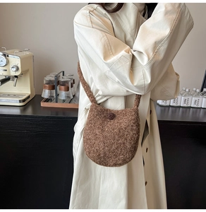 Detail of soft brown wool bucket bag with round button closure and plush texture
