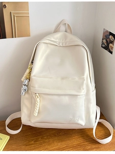 Minimalist cream white backpack with front pocket and a cute bear keychain ornament
