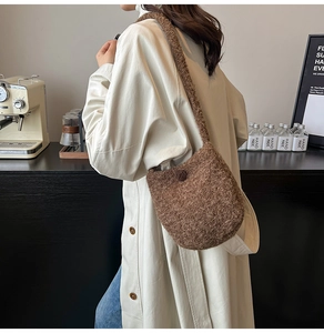 Brown wool shoulder bucket bag with button closure shown in a cozy cafe setting