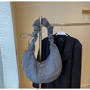 Close-up of the grey quilted nylon half-moon bag with a unique ruched shoulder strap design