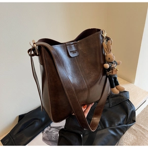 Detail of vintage brown tote bag with leather logo stamp and leopard bunny charm