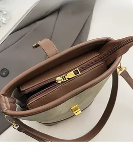 Close-up of color-block bucket bag showing smooth gold zippers and internal compartments