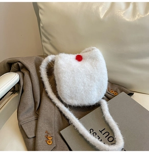 Detailed close-up of white plush bucket bag texture with a red decorative button