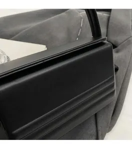 Detail of black box handbag featuring horizontal embossed leather and gold fashion lettering