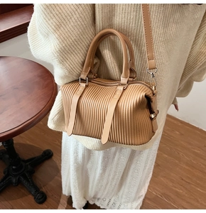 Detailansicht der karamellfarbenen Faltenhandtasche mit runden Griffen am Model