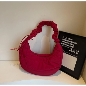 Detail of magenta crescent nylon bag featuring unique ruched cloud strap design