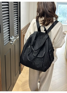 Close-up of durable black nylon backpack with reinforced handle and front zipper pocket