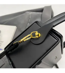 Detail of high-gloss gold hardware and premium matte black leather texture on box bag