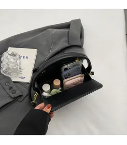 Interior view of black leather handbag showing spacious storage for phones and wallet