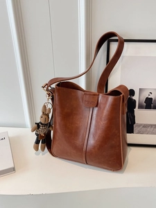 Vintage brown leather bucket bag with shoulder strap and cute rabbit charm detail