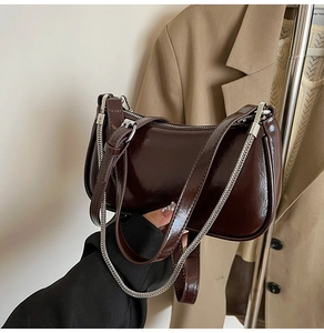 Details der dunkelbraunen Lackleder-Baguette-Tasche mit Silberkette und Glanzeffekt