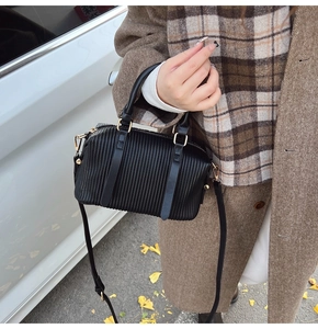 Details der schwarzen plissierten Boston Bag mit goldener Hardware und Schultergurt