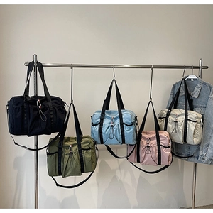 Dettaglio di borse da viaggio in nylon multicolore con tracolle regolabili e tasche laterali