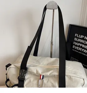 Dettaglio dei robusti manici neri e del materiale in tela resistente sulla borsa beige