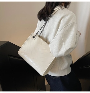 Dettaglio borsa shopper bianca lucida trapuntata con cuciture a V e catena nera