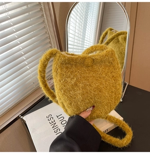 Detail of soft mustard yellow plush bucket bag featuring fuzzy faux fur texture