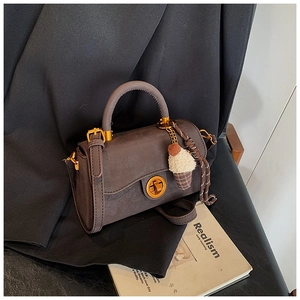 Details der kaffeebraunen Wildledertasche mit Goldschließe und Eiscreme-Anhänger