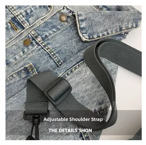 Détail du tissu denim bleu clair avec bandoulière réglable et bouton en métal