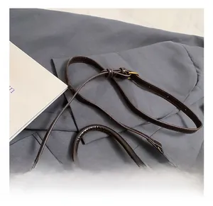 Dettaglio del manico e degli elementi dorati sulla borsa in pelle marrone scuro