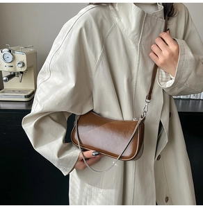 Braune Glanz-Hobo-Tasche aus PU-Leder mit Silberkette, von Model in Lifestyle-Szene getragen