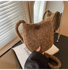 Detail of plush brown bucket bag with cat ear design and soft faux fur texture