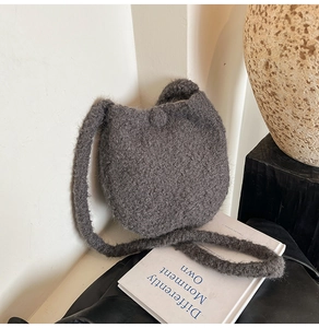 Detail of soft grey knitted plush bucket bag with fuzzy texture and matching shoulder strap