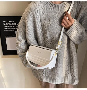 Detail of white leather crossbody box bag with embossed stripes and fashion lettering