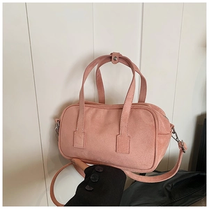 Detailed view of pink matte texture surface and reinforced stitching on crossbody bag
