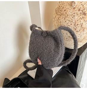 Close-up of charcoal grey wool knit bucket bag showing soft texture and button closure