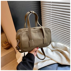Detailed macro of olive green frosted suede handbag with silver zipper and hardware
