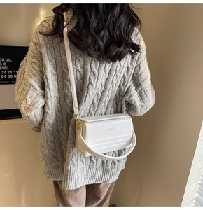 Detailed back view of a white minimalist square box bag with gold metal hardware