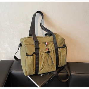 Dettaglio della borsa da viaggio in nylon verde scuro con cinghie e nastro tricolore