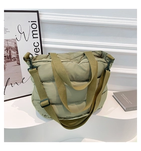 Détail du sac fourre-tout matelassé avec bandoulière réglable et texture douce de luxe