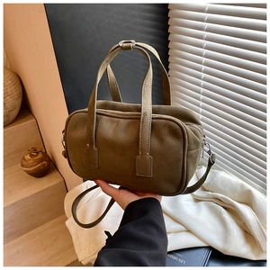 Detail of matte olive green crossbody bag with double handles and sleek zip closure