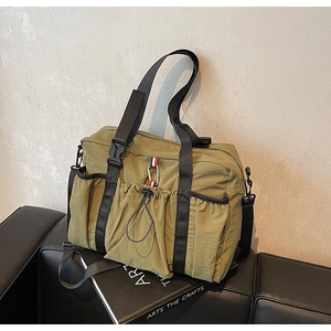 Dettaglio della borsa da viaggio in nylon oliva con tasche e fibbia metallica