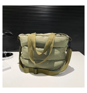 Vue macro du sac fourre-tout matelassé avec bandoulière réglable et fini mat lisse