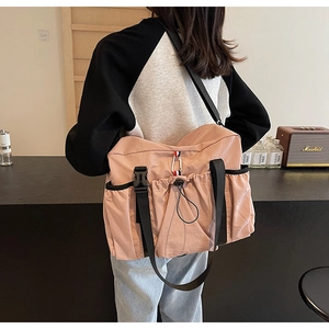 Dettaglio della borsa a tracolla in nylon rosa con tracolla regolabile e tasca