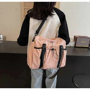 Dettaglio della borsa da viaggio in nylon rosa con tasca a coulisse e nastro tricolore