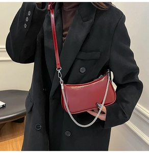 Details der burgunderroten Lackledertasche mit Silberkette und glänzendem Finish