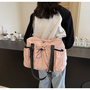 Dettaglio posteriore della borsa in nylon rosa con tasche a coulisse e tracolla nera