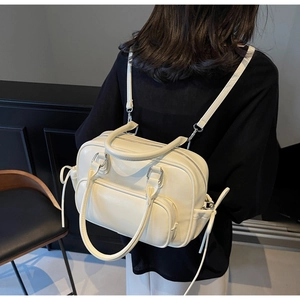 Detail of cream multi-functional backpack showing PU leather texture and silver zippers
