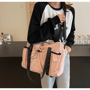 Dettaglio ravvicinato della borsa in nylon rosa con tracolla regolabile e fibbia