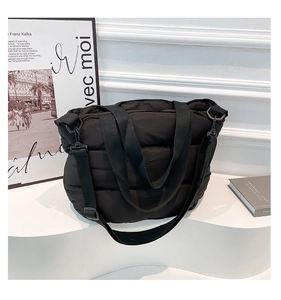 Détail du sac fourre-tout matelassé noir avec bandoulière réglable sur support